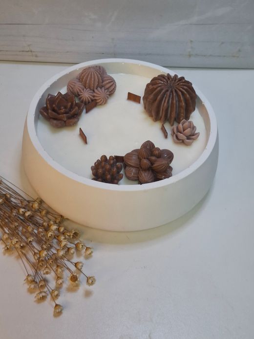 Vela aromática artesanal grande en recipiente blanco decorado con cactus y suculentas