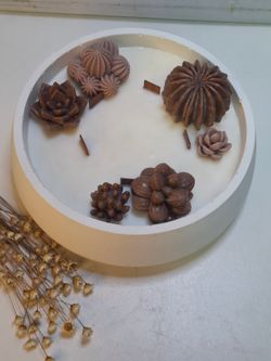 Vela aromática artesanal grande en recipiente blanco decorado con cactus y suculentas