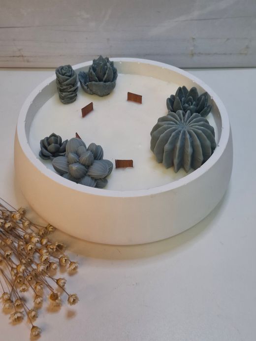 Vela aromática artesanal grande en recipiente blanco decorado con cactus y suculentas