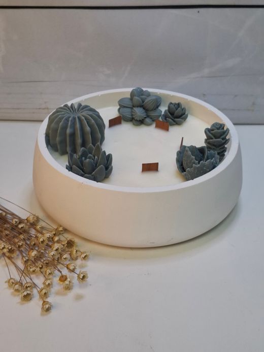 Vela aromática artesanal grande en recipiente blanco decorado con cactus y suculentas