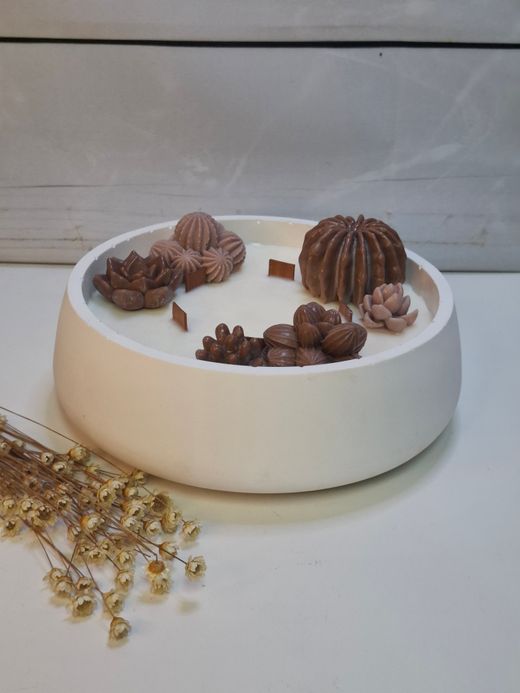Vela aromática artesanal grande en recipiente blanco decorado con cactus y suculentas