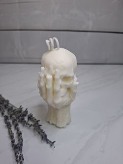 Vela decorativa calavera con mano esquelética